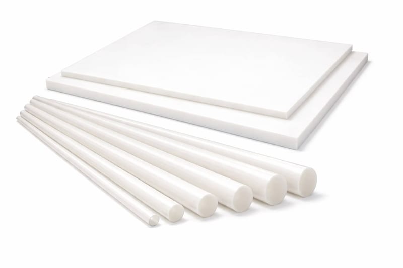 Two white PTFE sheets stacked flat, with six white PTFE rods fanned out beside them from thin to thick